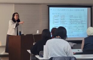 　令和8年1月25日、以前より会員の皆さんから要望が多かった親子のアタッチメントについて、山梨英和大学非常勤講師、臨床心理士の森稚葉先生をお迎えして研修会が開催されました。「親子の絆の土台作りー助産師だから出来る関わり」というテーマのもとご講演頂きました。 　森先生にアタッチメントについてこ講演を依頼することになった経緯は、研修会係の話し合いの中から、時代や社会とともに変化する、今どきのお母さんたちの傾向や思いを知り、親子に早期段階で関わることの多い私たち助産師ができることを考察したいという思いからはじまりました。 　講演ではアタッチメントの機能や発達のプロセスについて学び、母子の相互作用や個人差について、森先生の体験談なども含め、わかりやすくまた楽しくお話しいただきました。 　母子の相互作用の研究、「Still Face Procedure （静止顔実験）」はYouTube でも研究動画と解説をみることができるとご紹介いただきました。赤ちゃんは4ヶ月頃にはすでに親との情緒的相互作用の記憶を持ち、親の情緒を引き出そうとしたり、自分の情緒を調整しようと試みることが理解できる動画です。研修会に参加できなかった会員の皆様にもでひご覧いただけたらと思います。 　大人のアタッチメントタイプの分類やアタッチメントの歪みなどについても紹介されました。 　まとめとして、森先生より示唆いただいたことを以下に要約します。　周産期に母子に出会う助産師ができることは、母親の置かれている現在の環境や心情を理解すること。母親が子どもと過ごす中で体験する様々な感情に寄り添うこと。赤ちゃんの体験についてともに関心を寄せ、思いを巡らし一緒に考える伴走者となること。 　複雑なテーマを臨場感を持ってお話ししてくださった森先生はとても魅力的で、ぜひ森先生の講演会、第2弾を期待したいです。